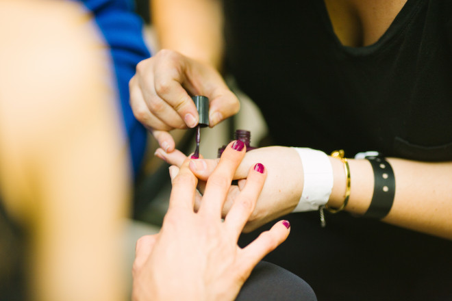 Imagem de uma mulher cuidando das unhas de outra mulher.